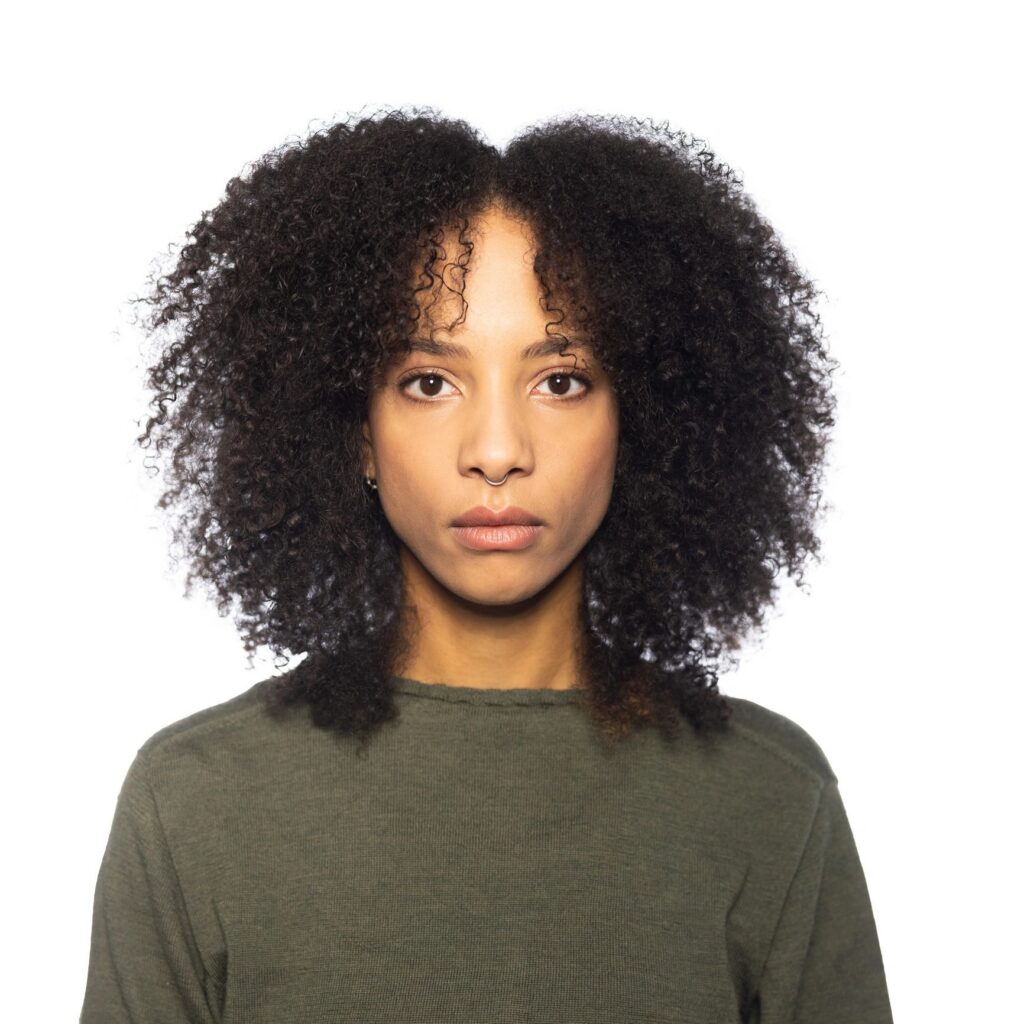 Studio Portrait of a Serious Woman of Mixed Ethnicity with Curly Hair